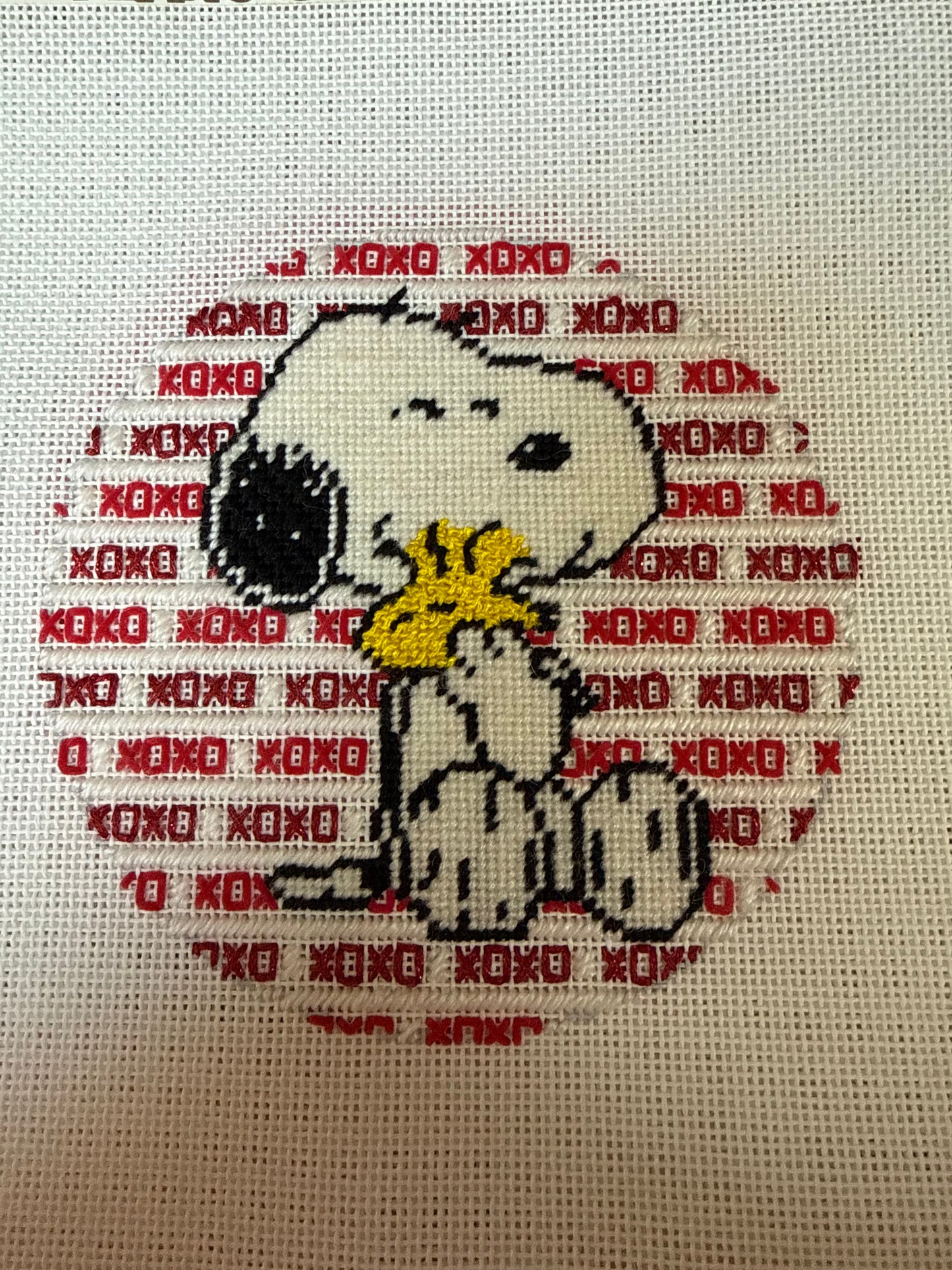 Stitched Needlepoint Canvas of Snoopy hugging Woodstock with decorative backdrop