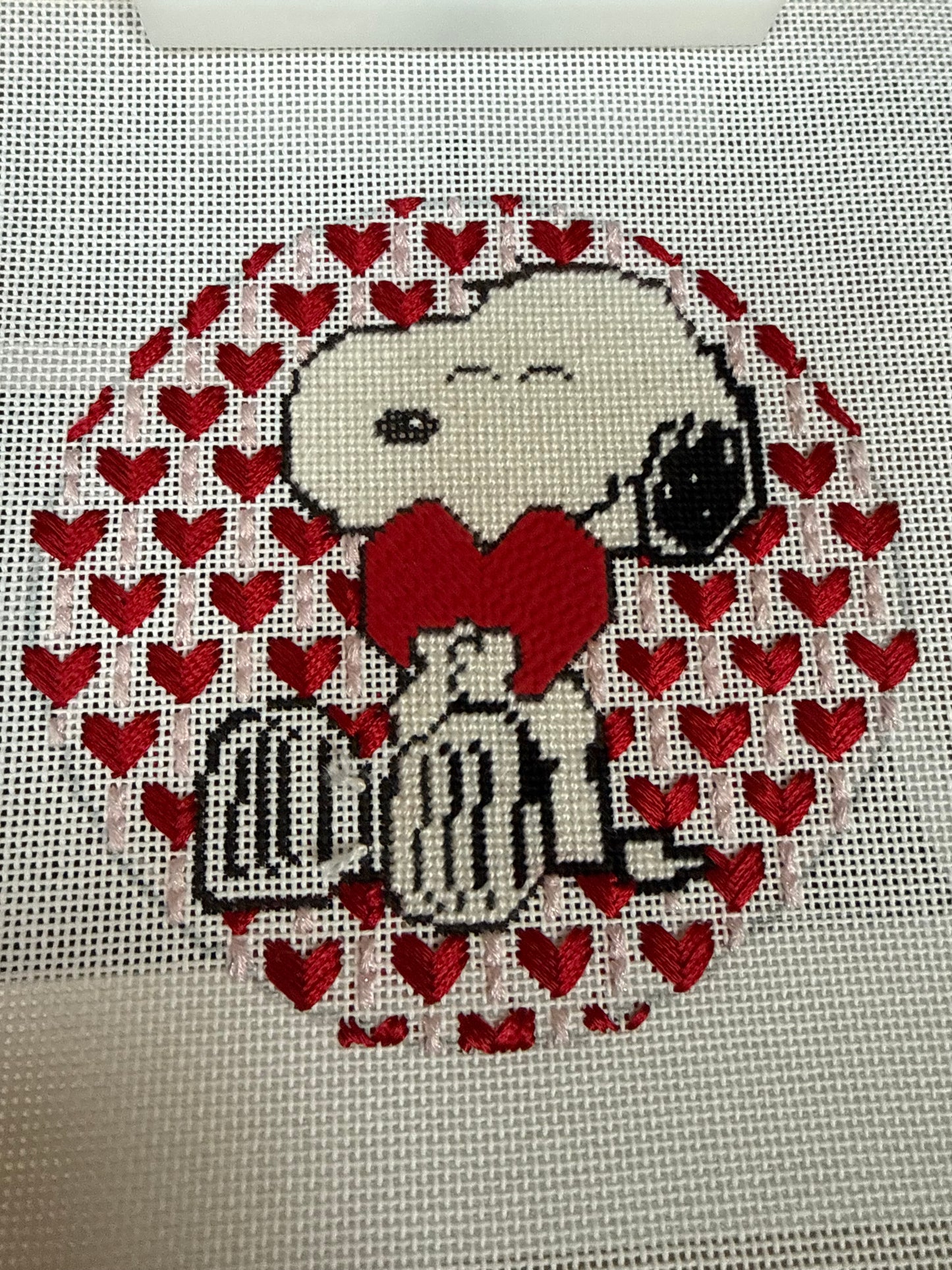 Stitched Needlepoint of Snoopy hugging heart on decorative background